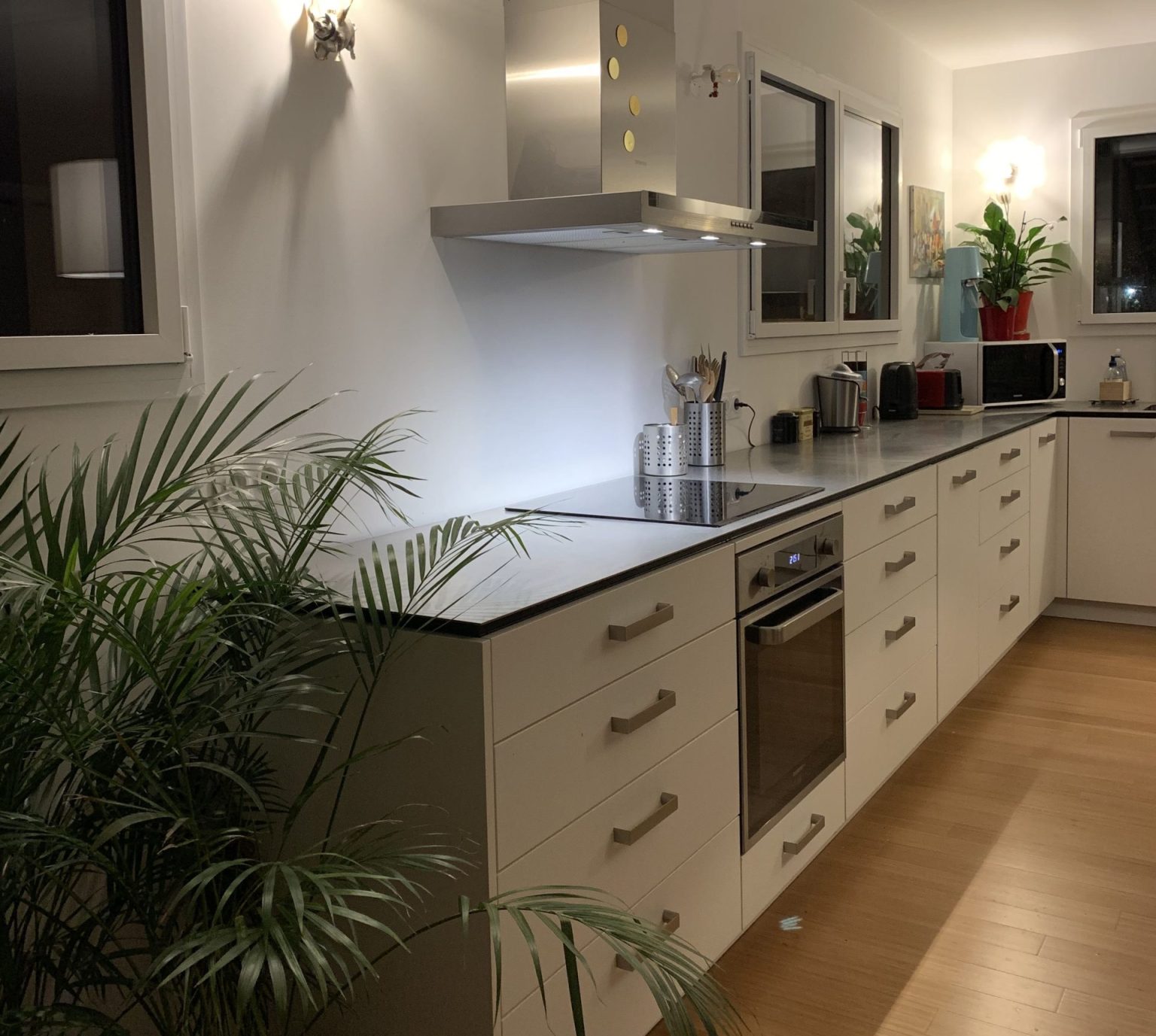 cuisine sur mesure blanche avec luminaires et matériaux fénix